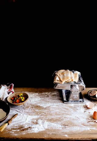 A rustic wooden table filled with bags of flour, fresh cream, and milk bottles, ready for baking.