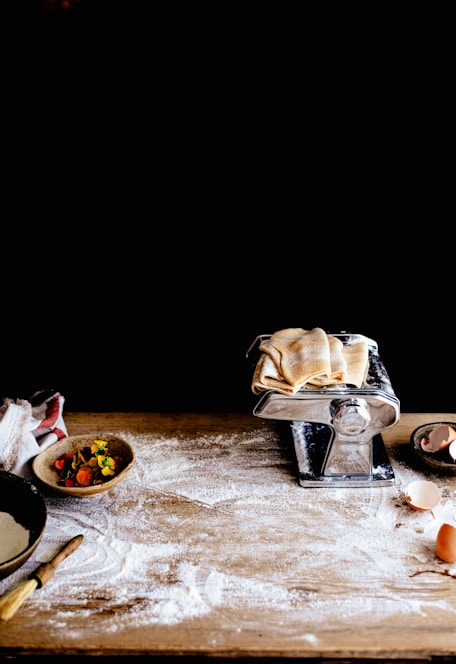 A rustic wooden table with bags of flour and grains scattered around.