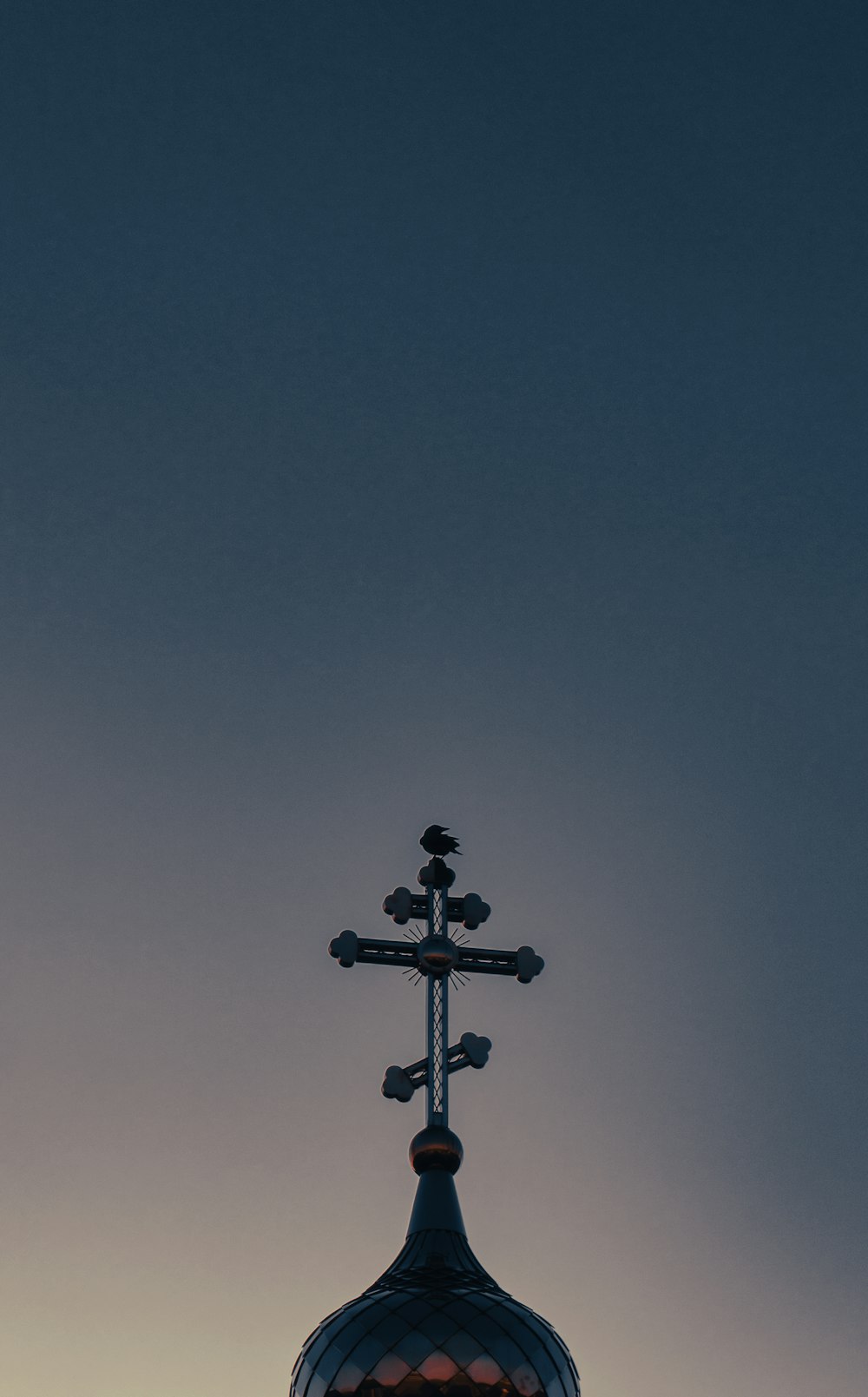 a cross on top of a building with a sky background