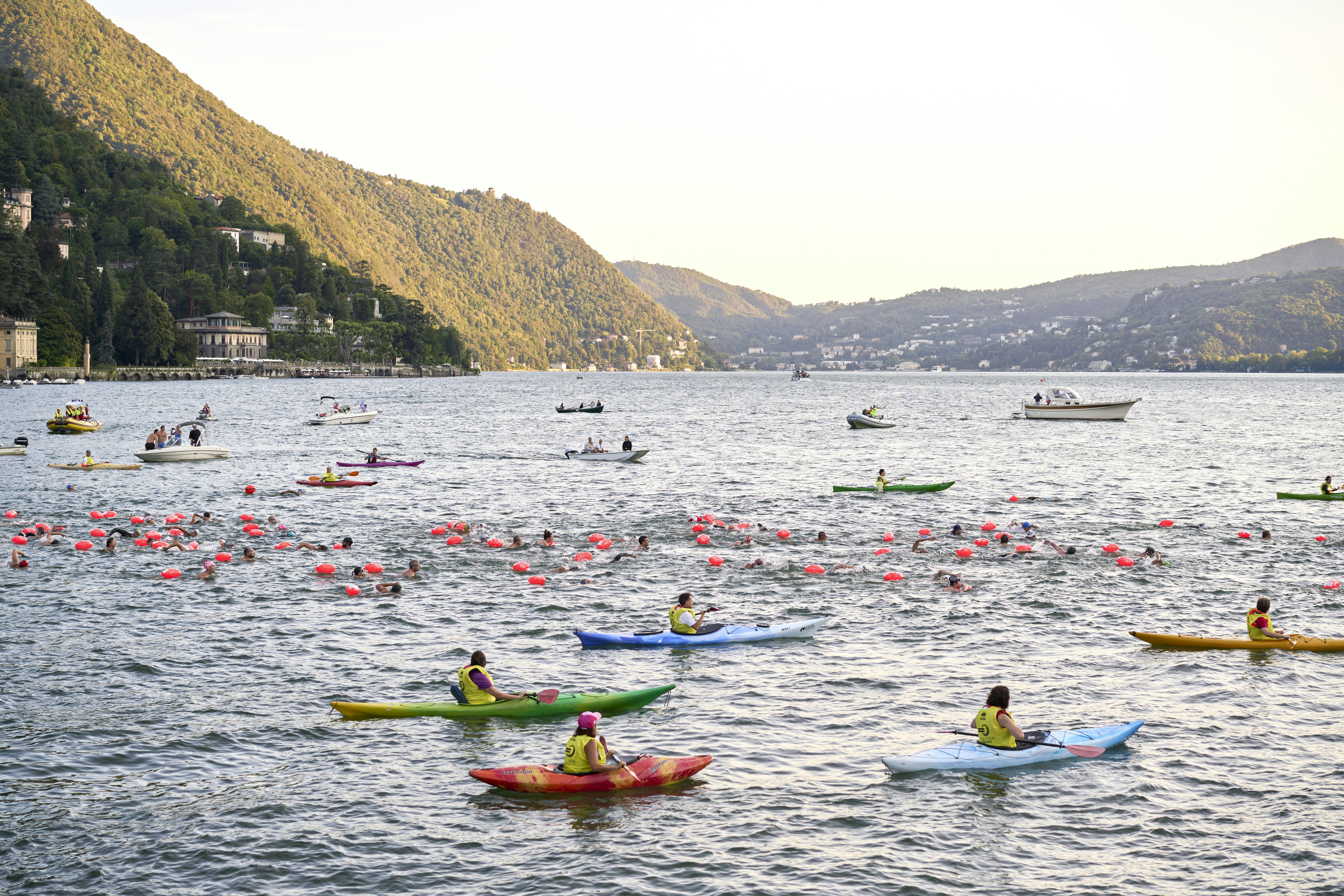 a group of people in kayaks paddling on a lake, 