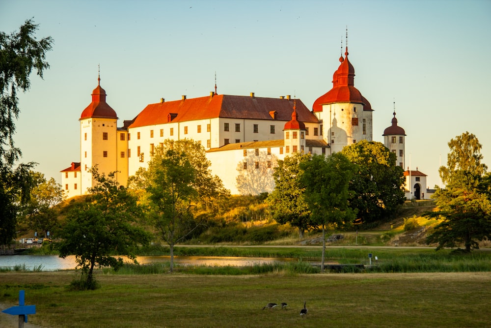 a large white castle sitting on top of a lush green field