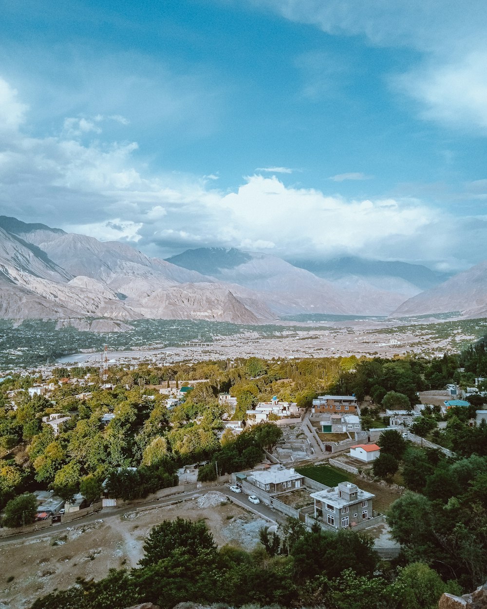 a scenic view of a city with mountains in the background