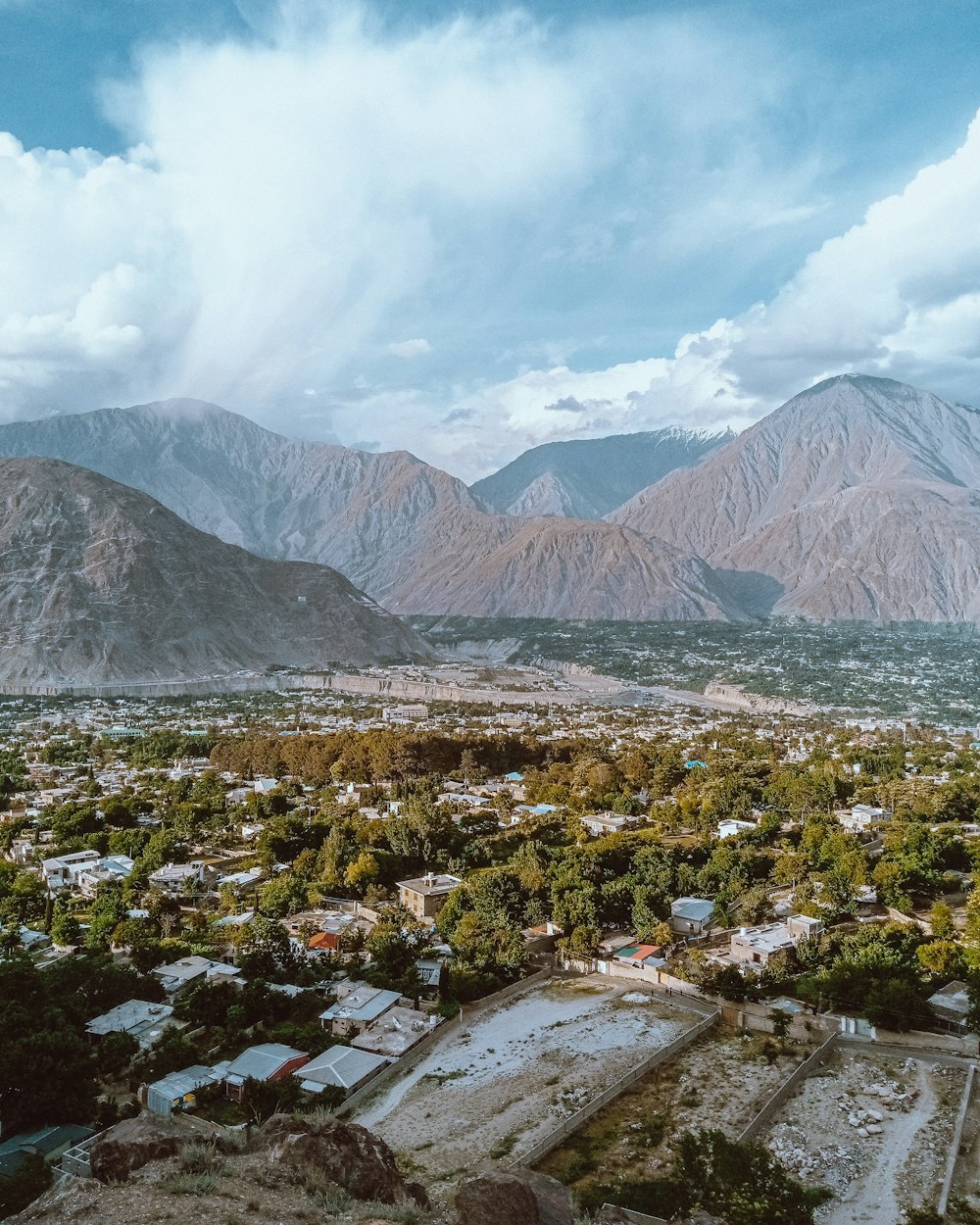 an aerial view of a city with mountains in the background