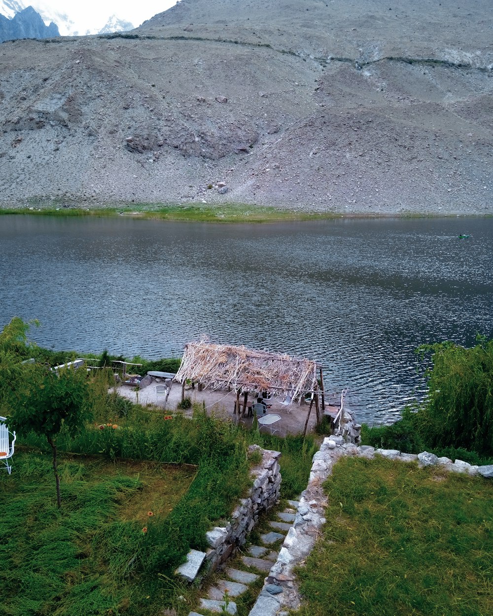 an abandoned boat sitting on the shore of a lake