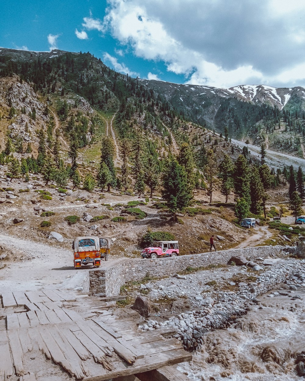 a group of vehicles parked on a dirt road