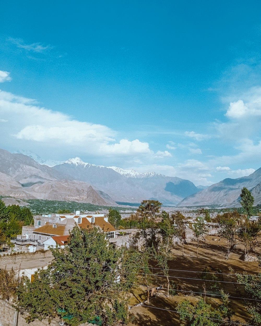 a scenic view of a town with mountains in the background