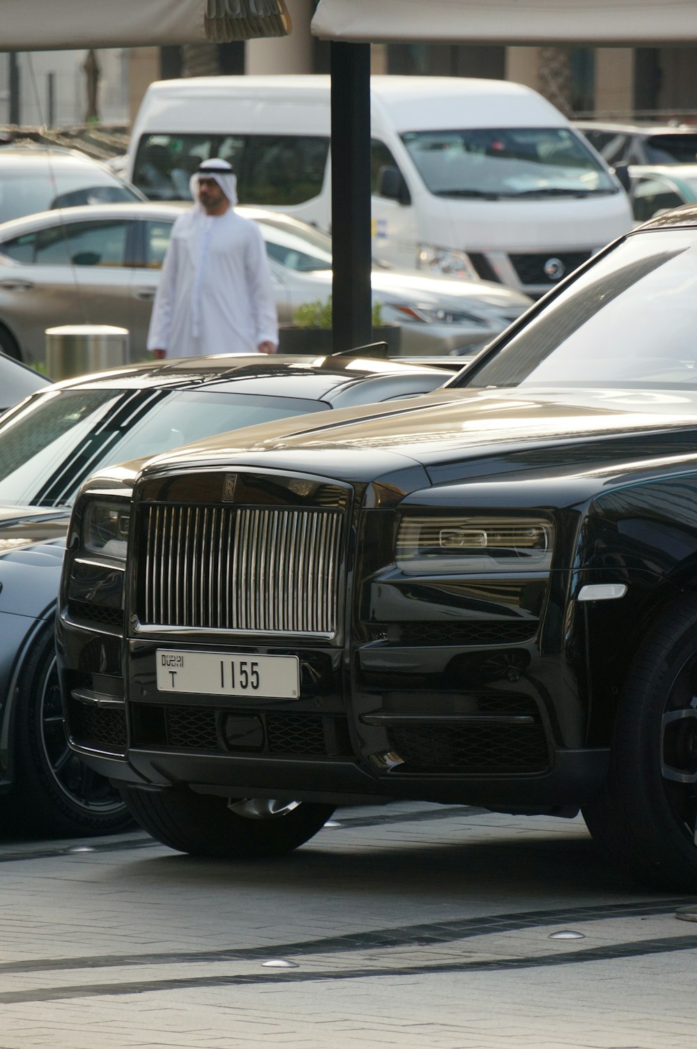 a man walking past a row of parked cars