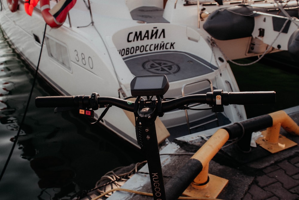 a close up of a bike parked next to a boat