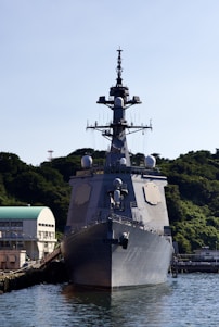 a large military ship docked at a dock