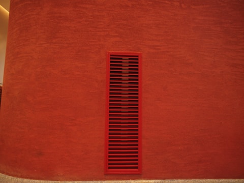 Interior accent wall with smooth red rock panels and soft lighting.