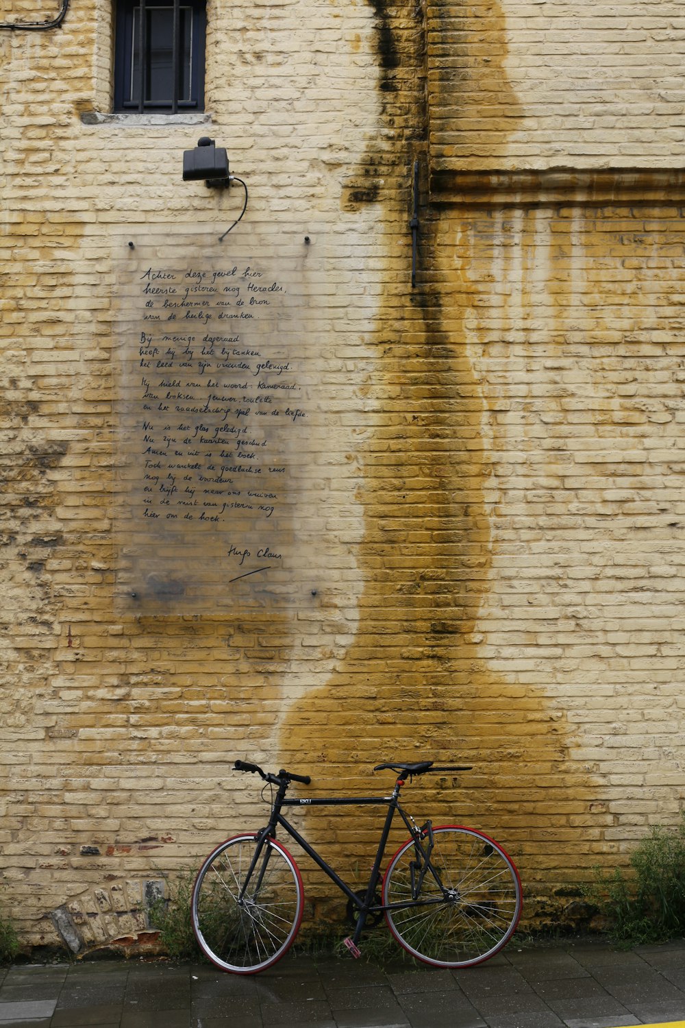 a bicycle leaning against a brick wall with writing on it