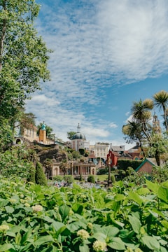 An aerial shot of a vibrant cultural village surrounded by lush greenery and winding paths.