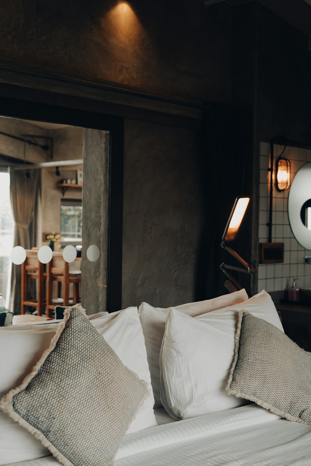 a bed with white sheets and pillows in a room