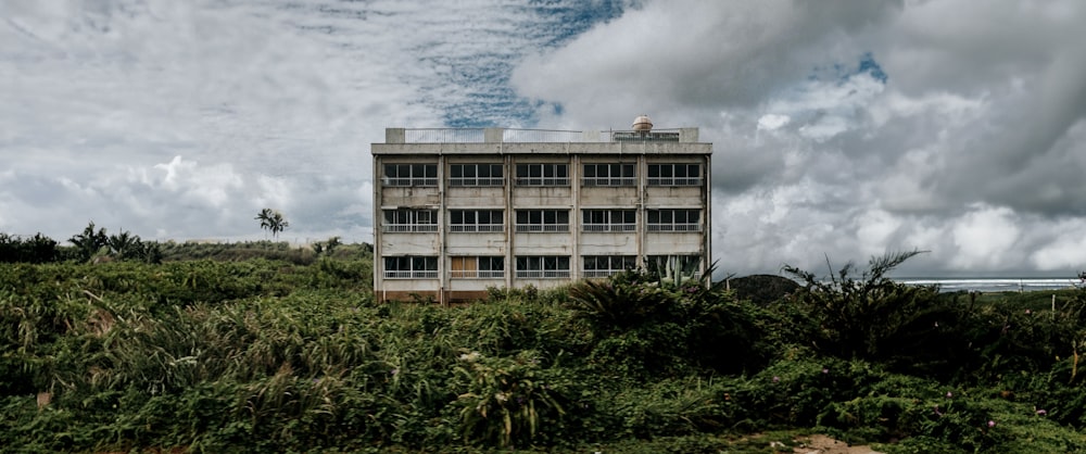 an abandoned building sitting on top of a lush green field