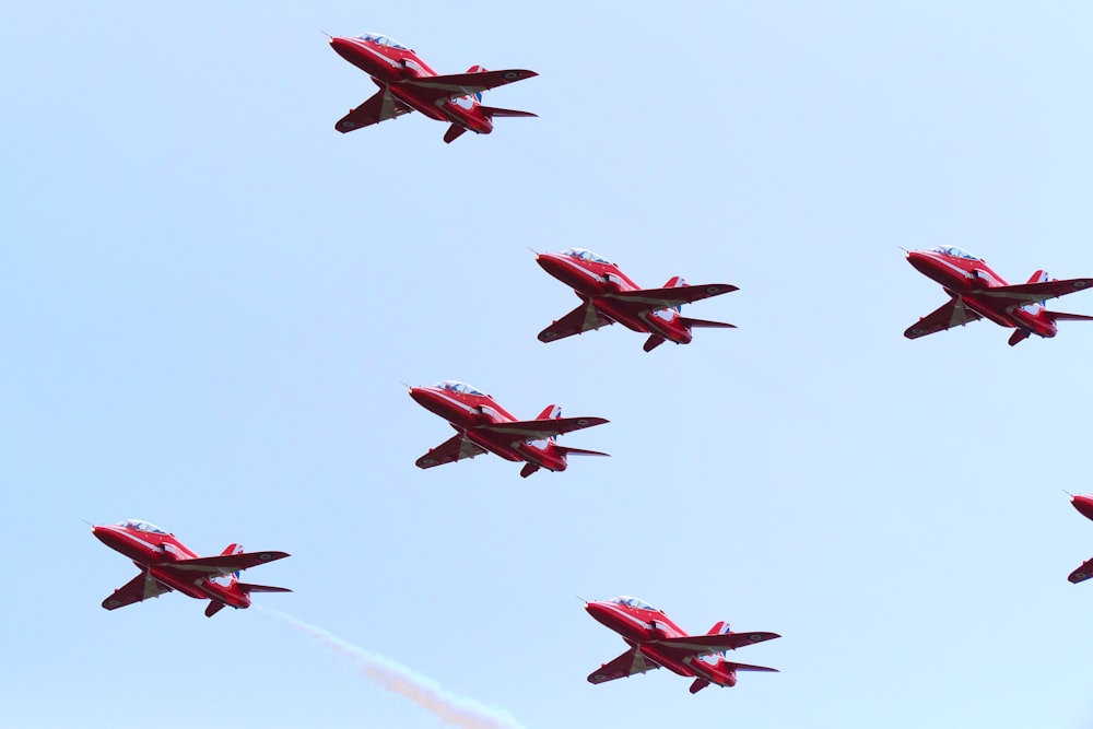 a group of jets flying through a blue sky