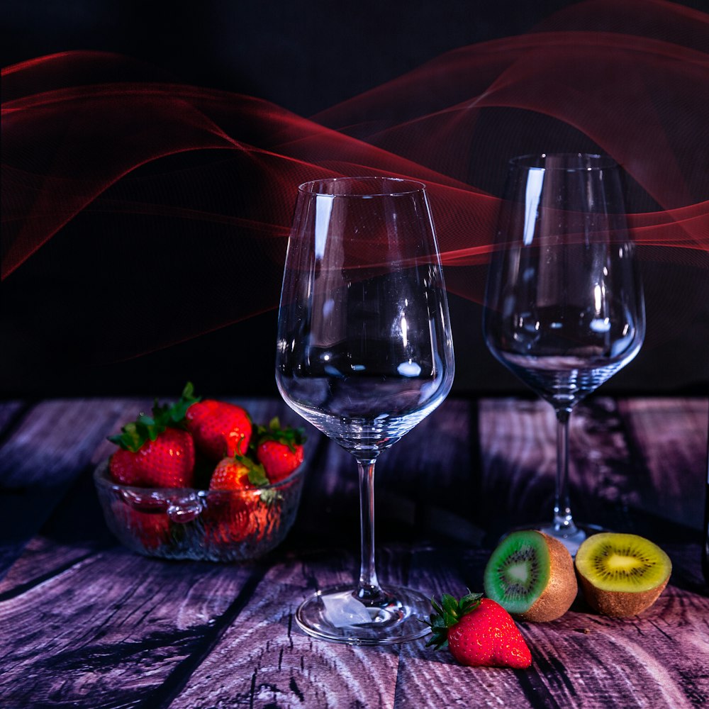 a couple of wine glasses sitting on top of a wooden table