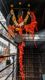 Close-up of Shiva's trident adorned with flowers during a temple festival.