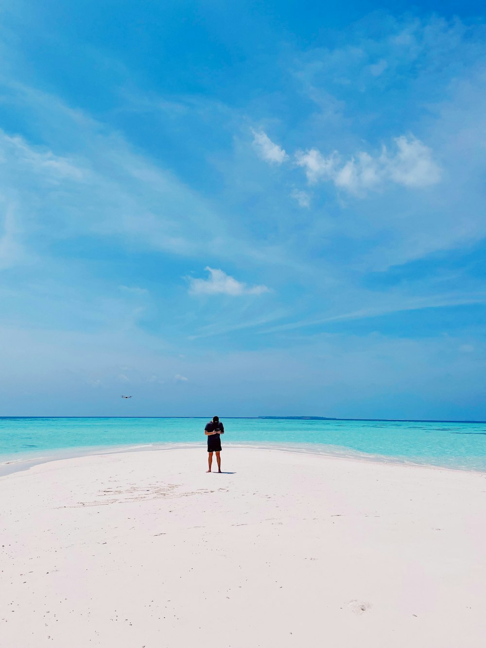 a person standing on a beach with a kite in the air