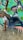 A person in a white t-shirt and jeans performs an impressive breakdance move against a colorful graffiti wall. The vibrant mural features abstract shapes and splashes of teal, purple, and pink.