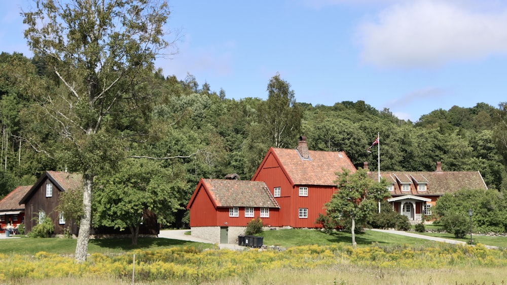 a red house surrounded by trees and grass