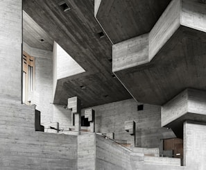 Interior view of a brutalist space with exposed concrete walls and minimalist furnishings