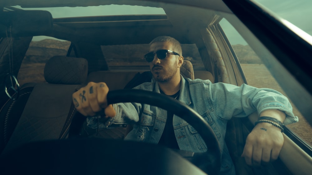 a man sitting in the driver's seat of a car