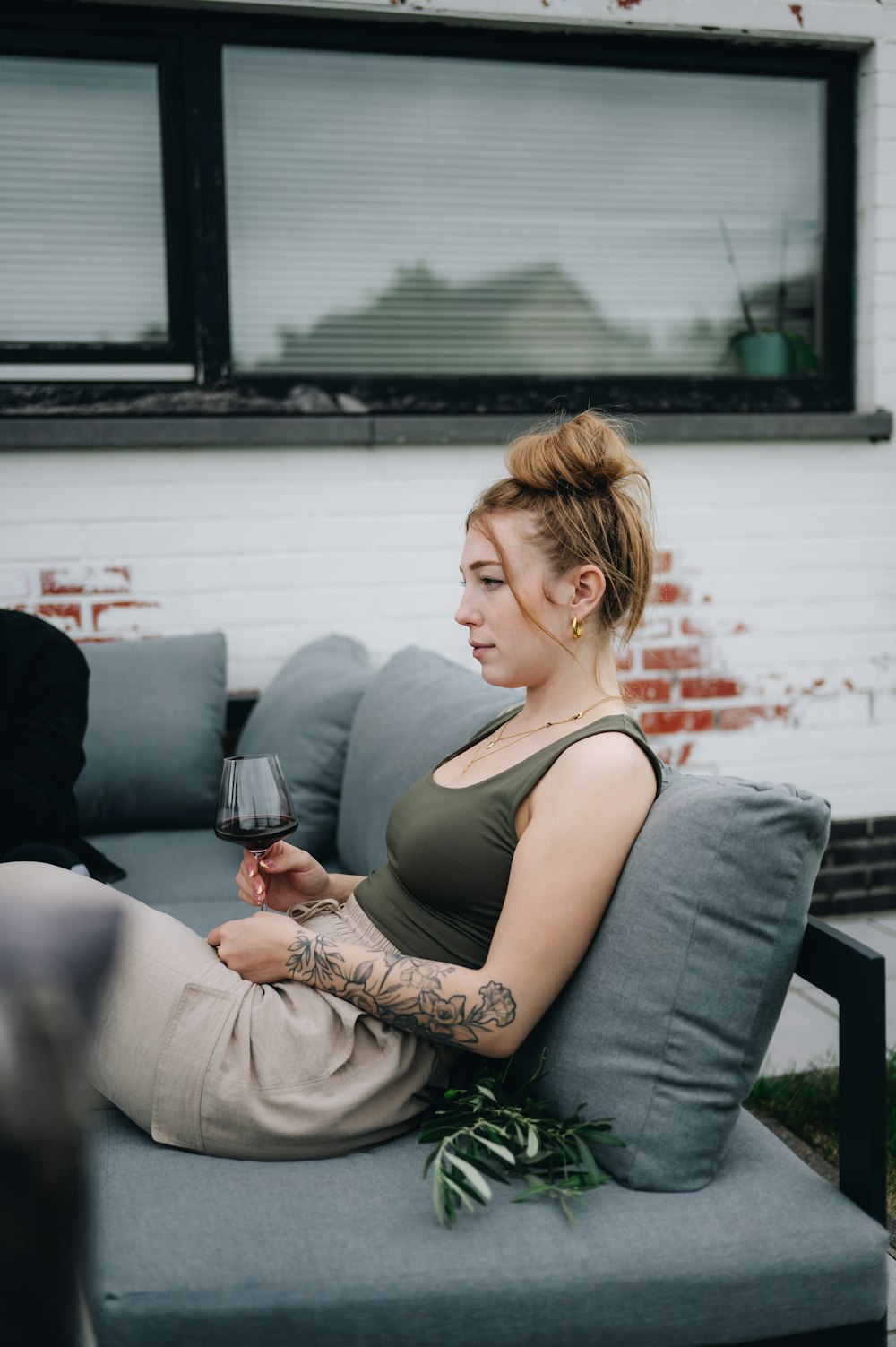 a woman sitting on a couch holding a glass of wine