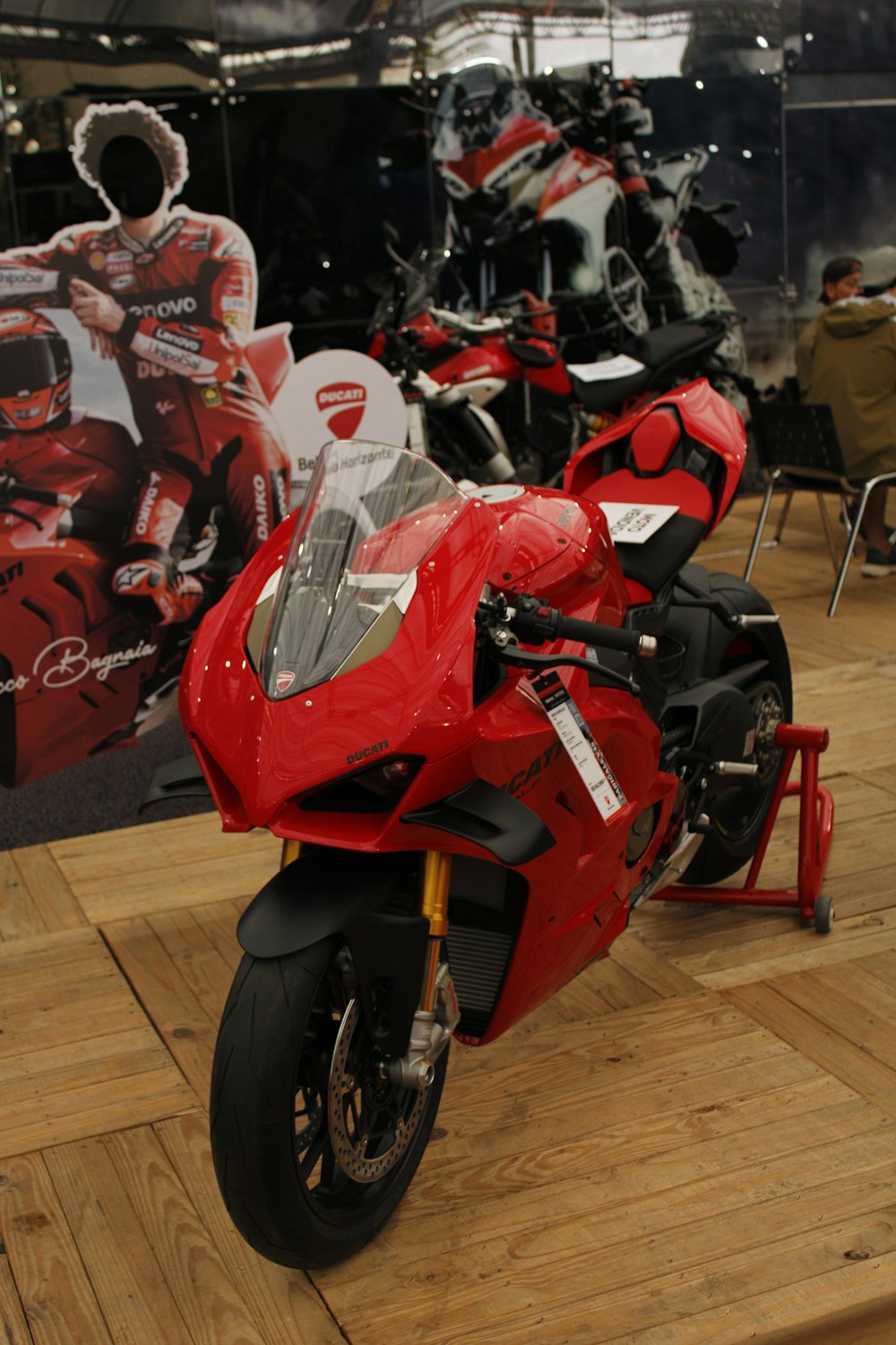Una motocicleta roja estacionada encima de un piso de madera dura
