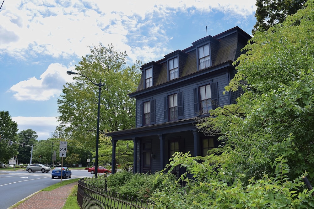 a large black house sitting on the side of a road