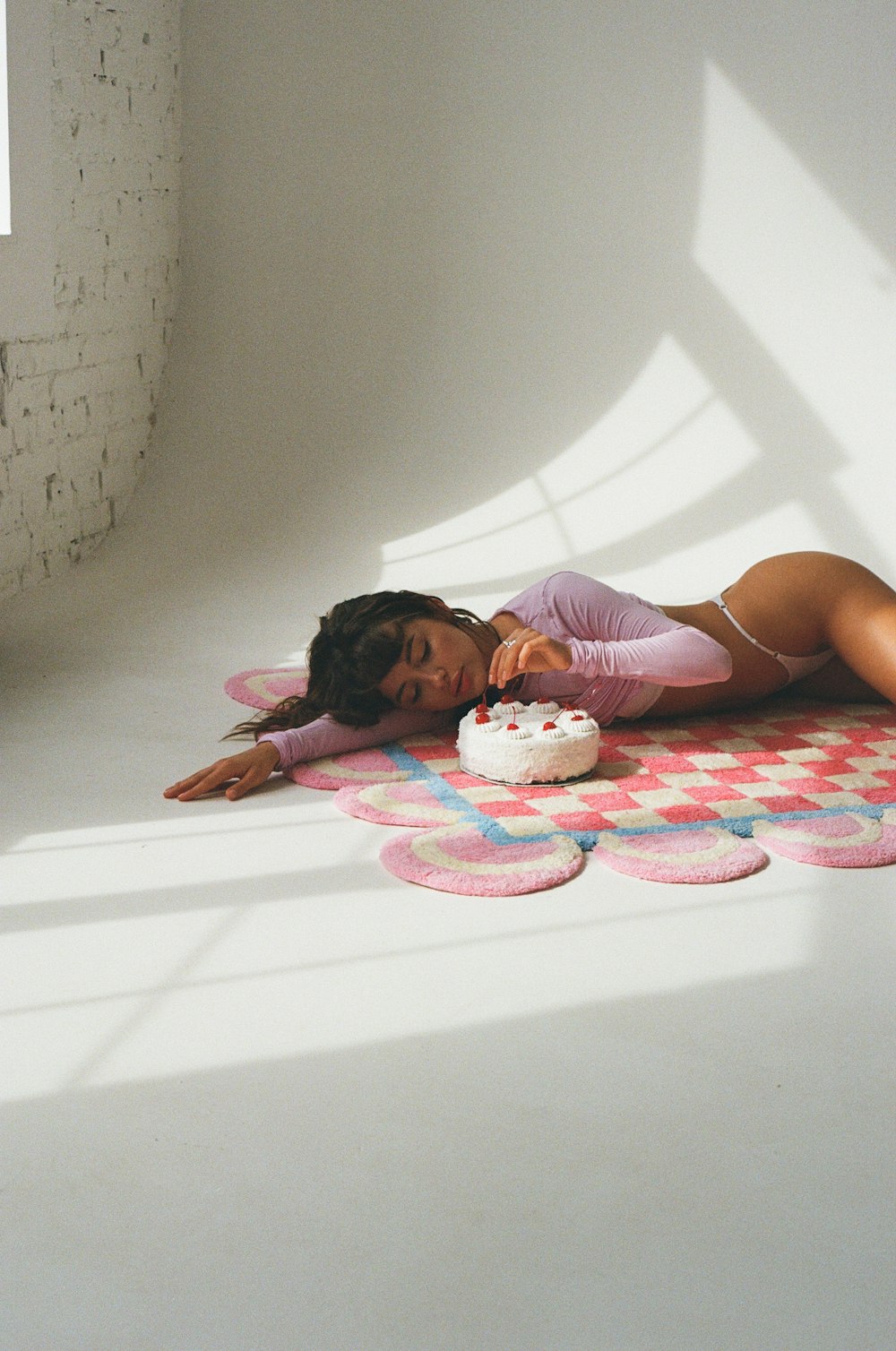 a woman laying on the ground with a cake