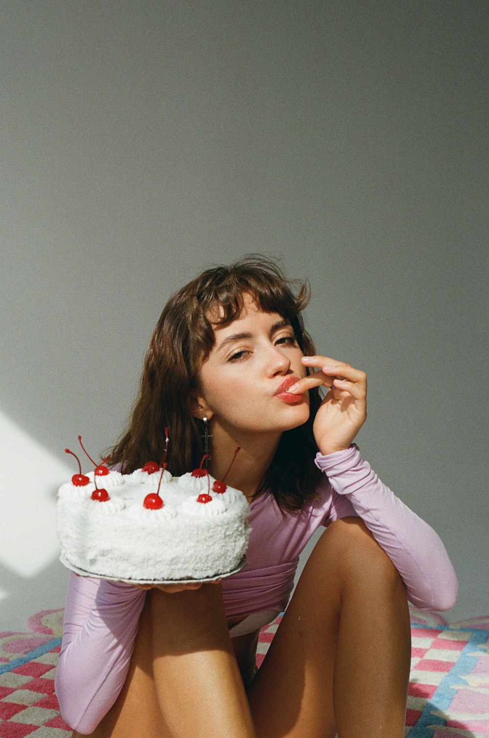 Une femme assise par terre avec un gâteau