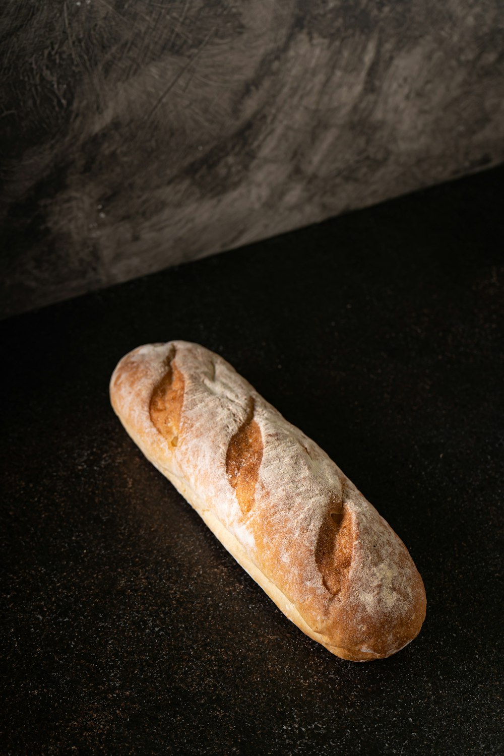 Una barra de pan encima de un mostrador negro