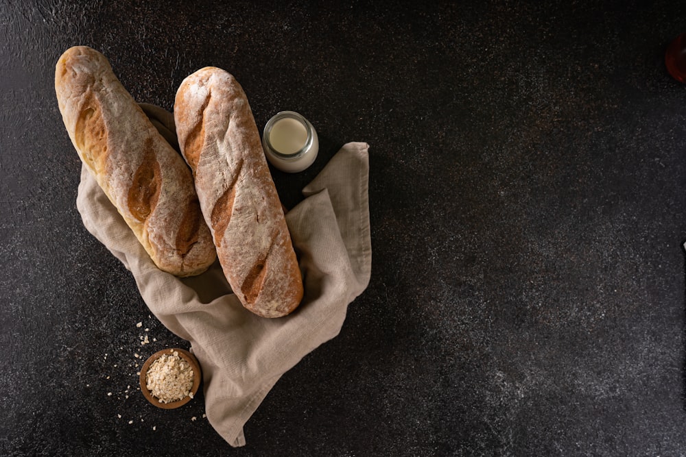 two loaves of bread sitting on top of a napkin