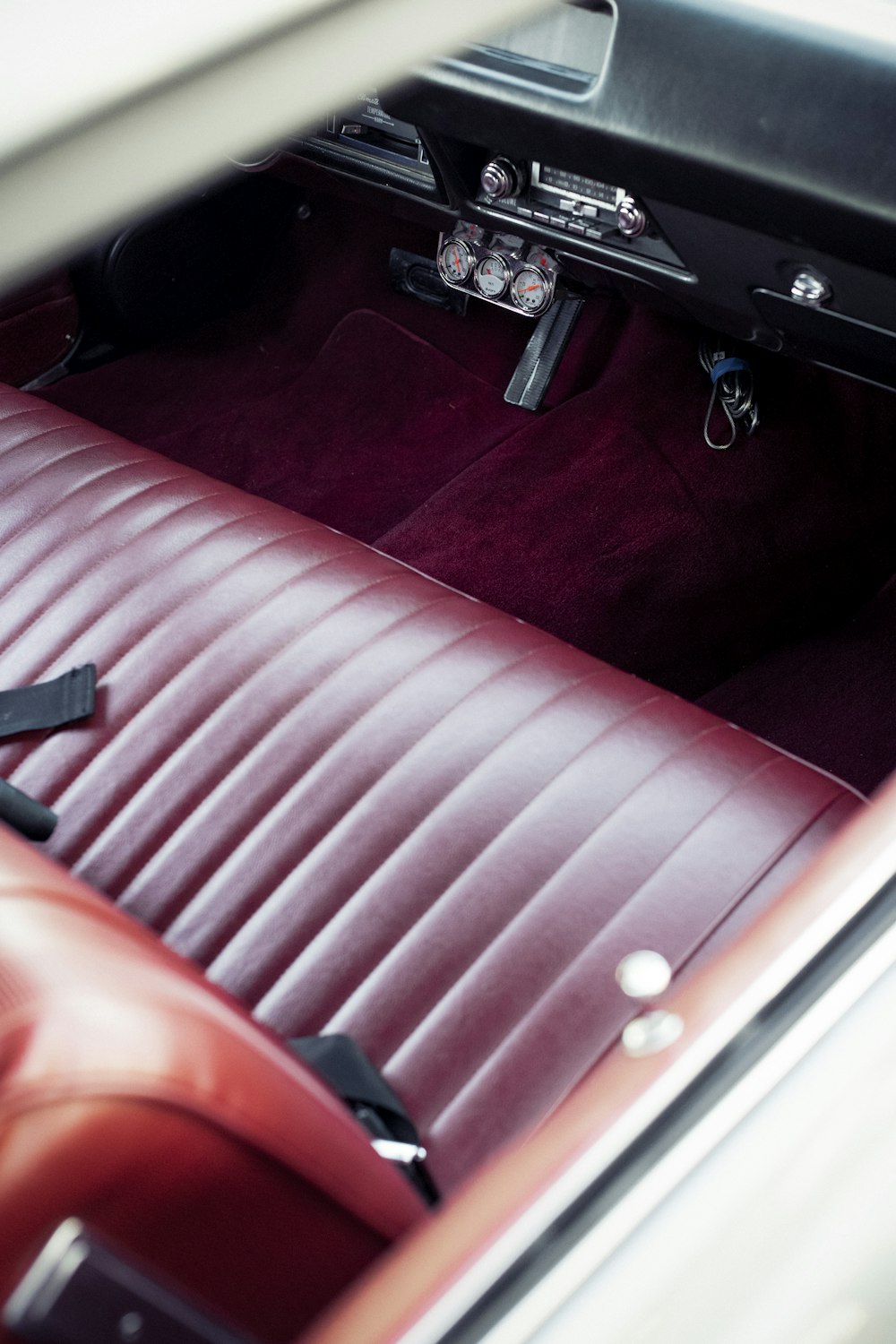 the interior of a car with a red leather seat