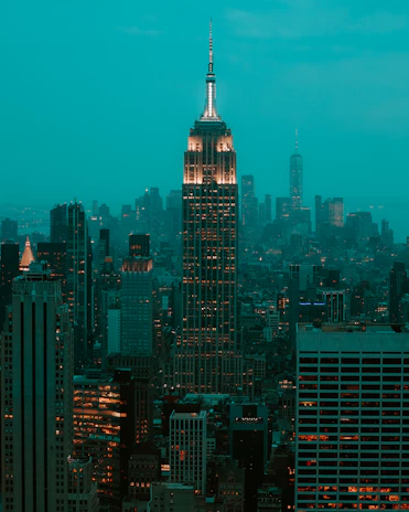 Nighttime shot capturing the building’s illuminated facade against the city skyline.