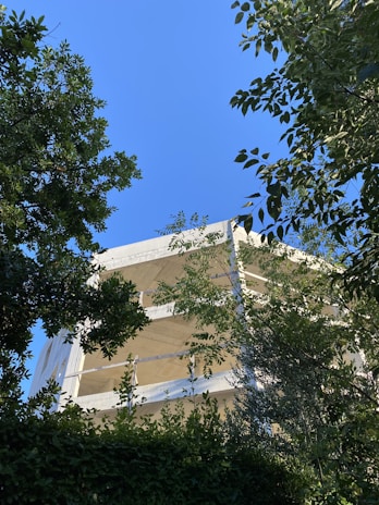 Exterior view of a Bayvue villa under construction, framed by lush greenery and clear skies.