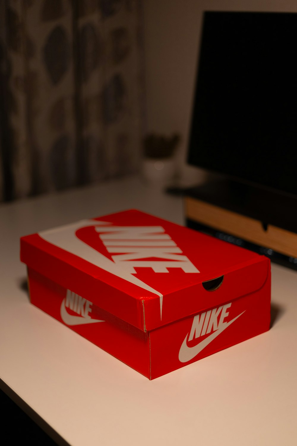 a red nike box sitting on top of a table