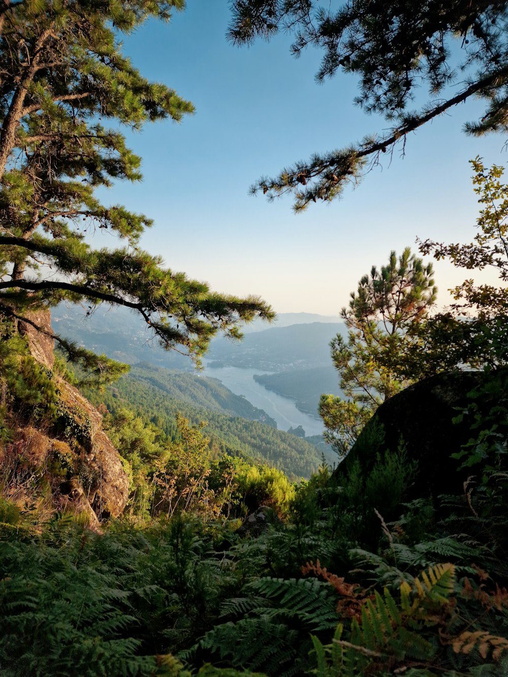 a scenic view of a mountain range with a lake in the distance