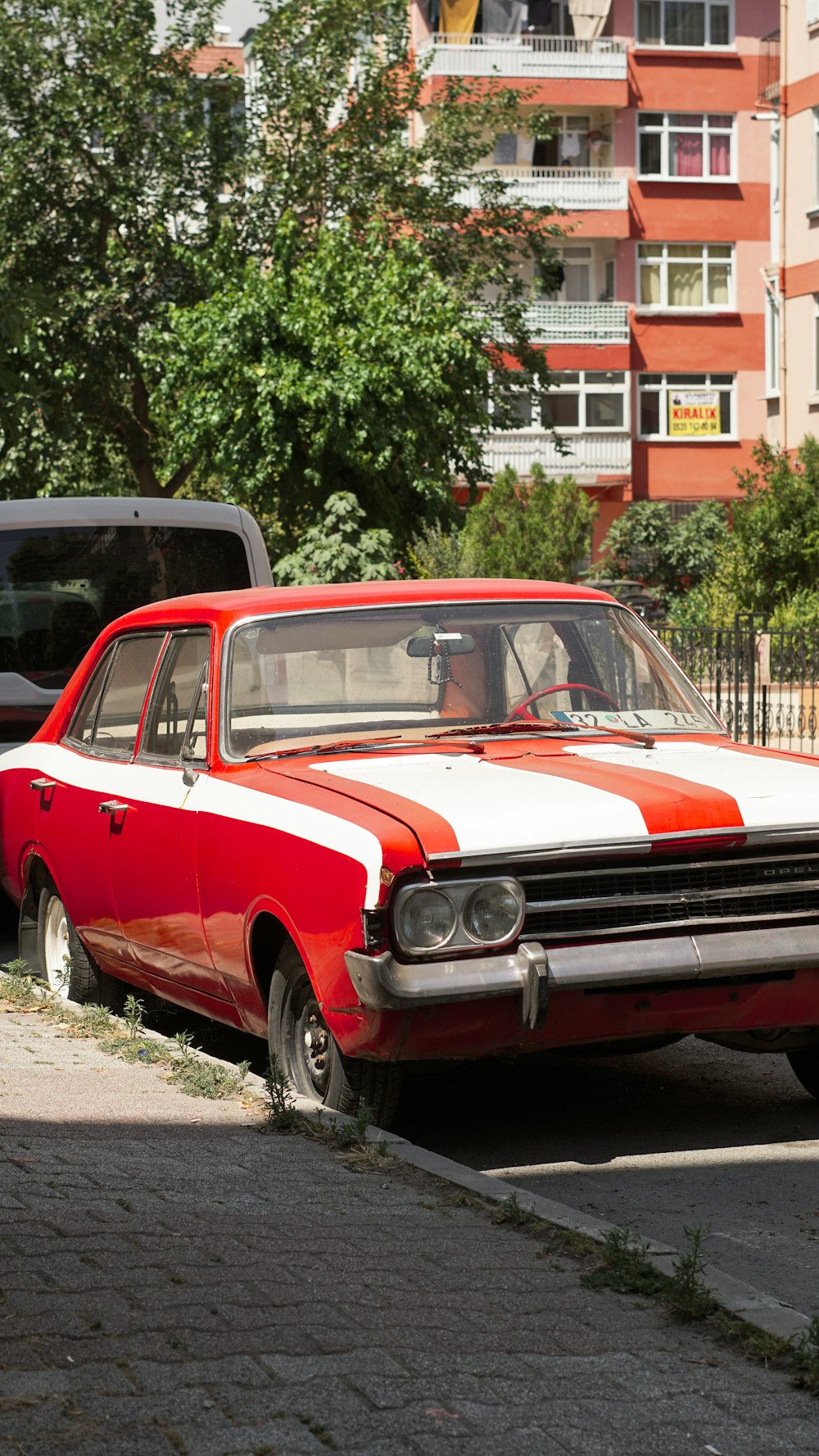 a red and white car parked on the side of the road