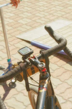 Close-up of a sleek GPS tracker attached to a motorcycle handlebar in an urban setting.