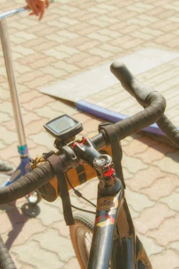Close-up of a sleek GPS tracker attached to a motorcycle handlebar in an urban setting.