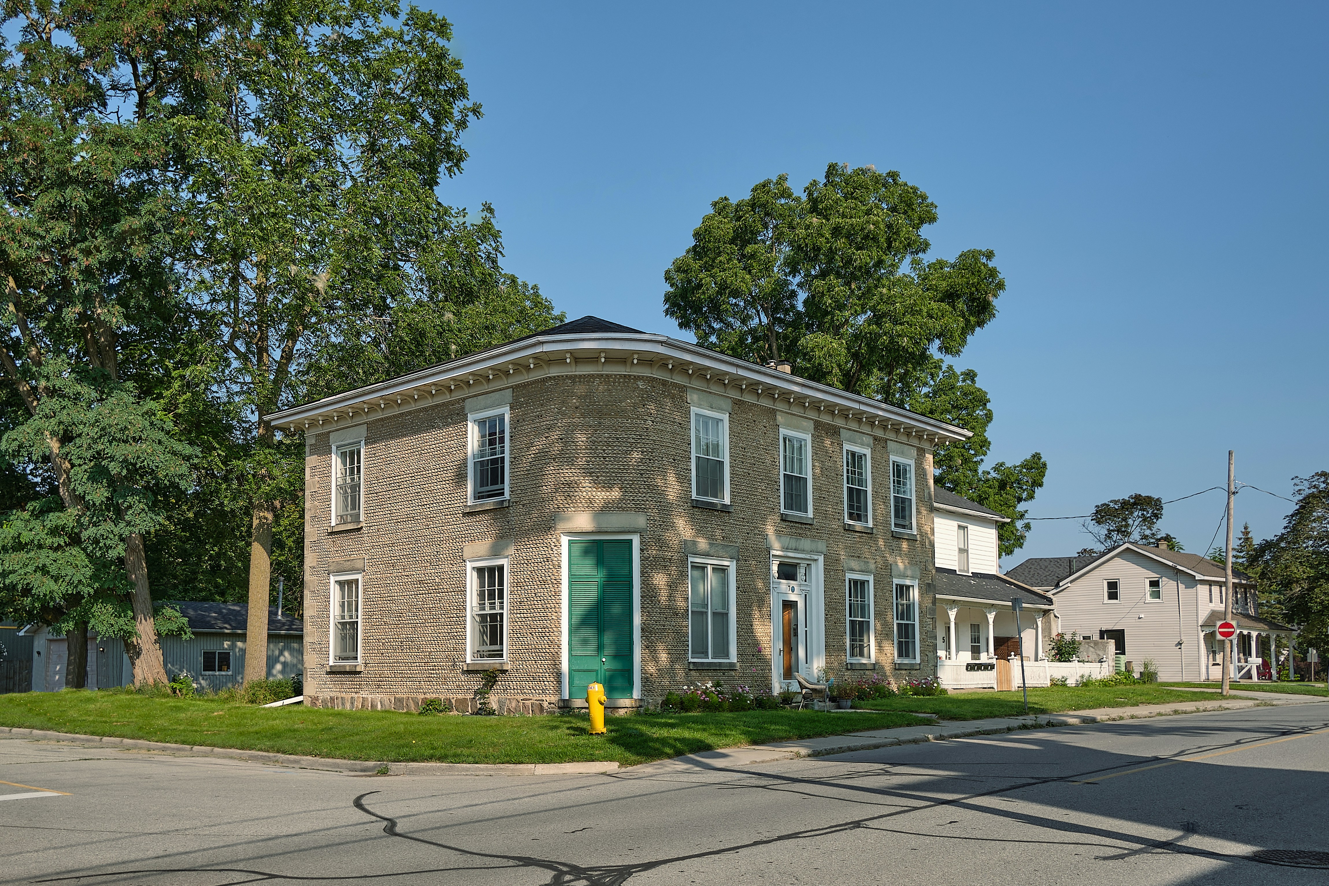 a brick building with a green door on the corner of a street