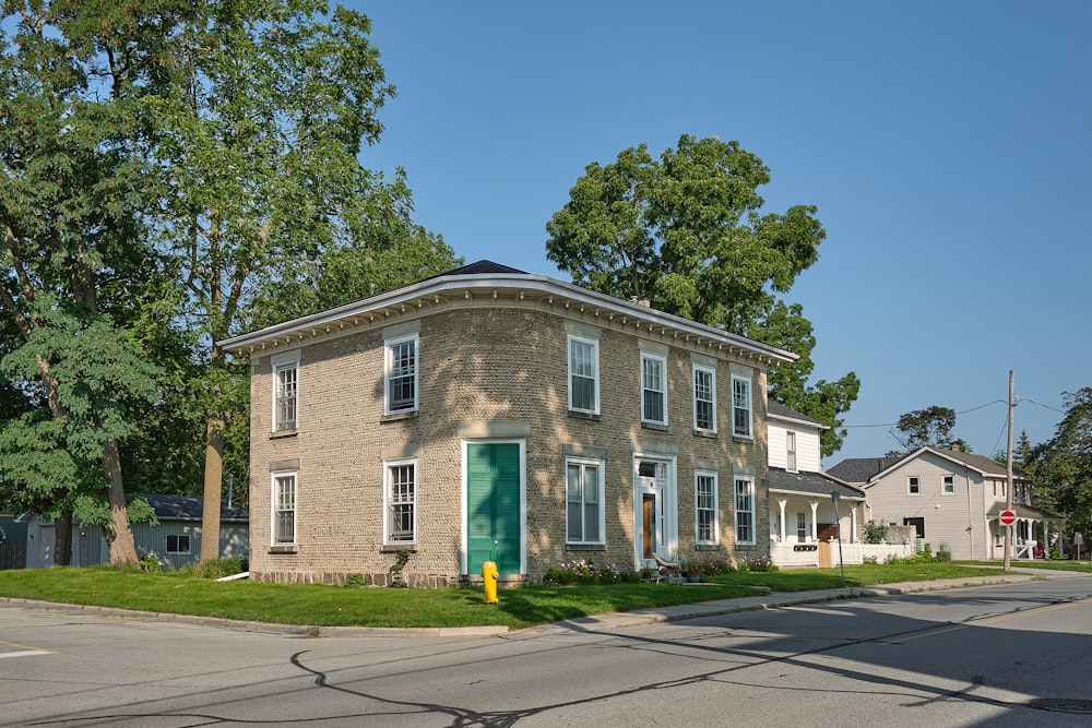 a brick building with a green door on the corner of a street