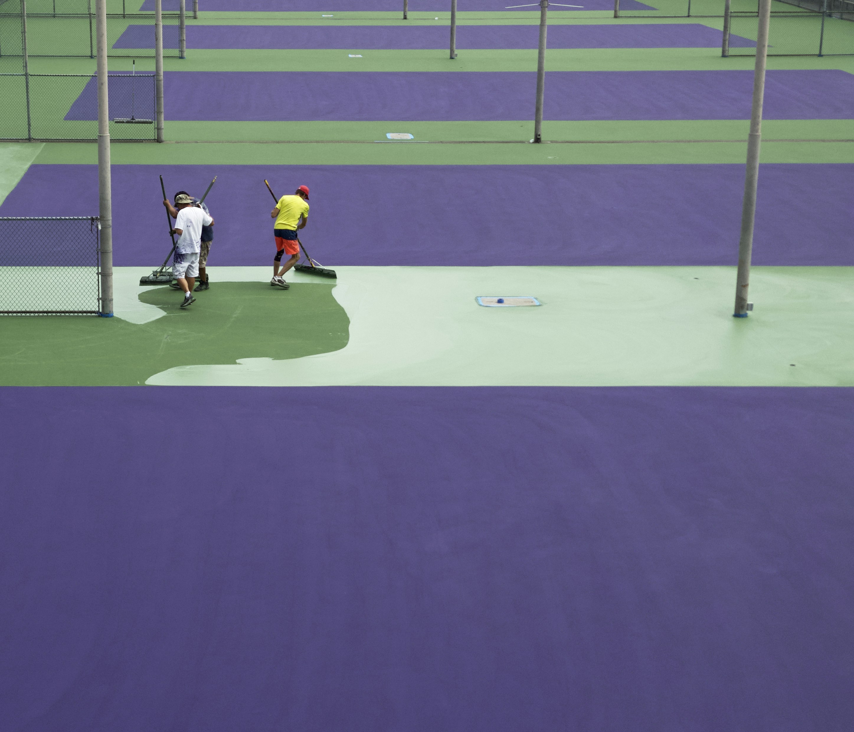 a group of people standing on top of a tennis court