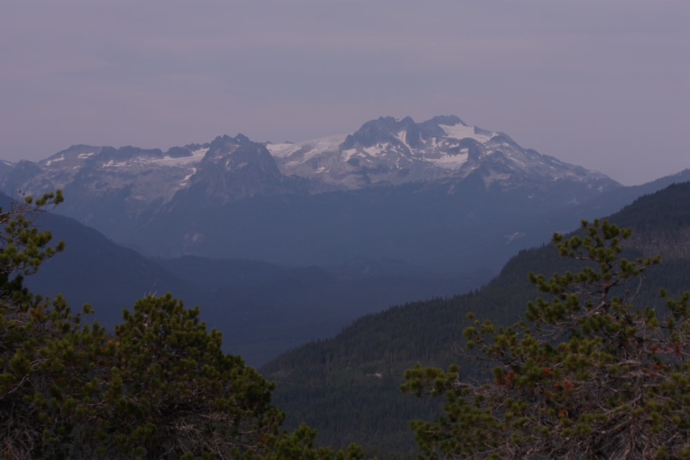 Una cadena montañosa con montañas cubiertas de nieve en la distancia