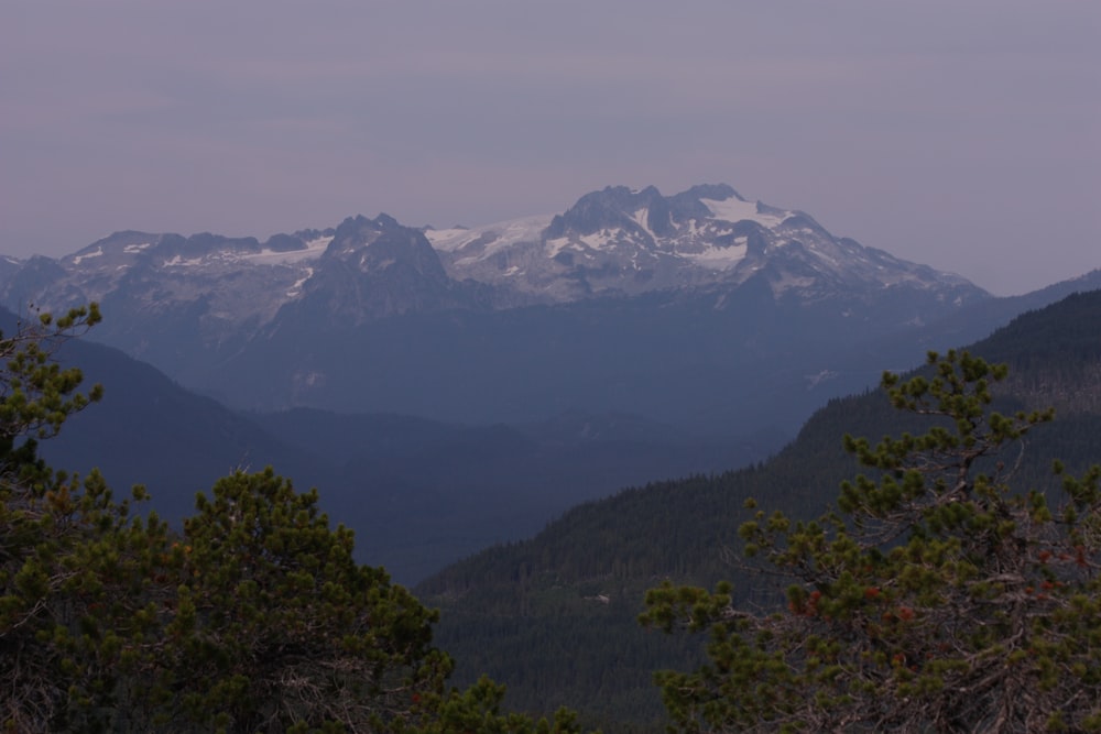 a mountain range with snow capped mountains in the distance