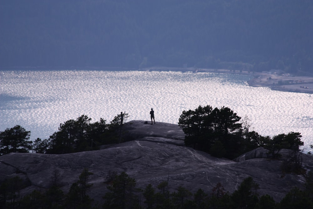 a person standing on top of a large rock