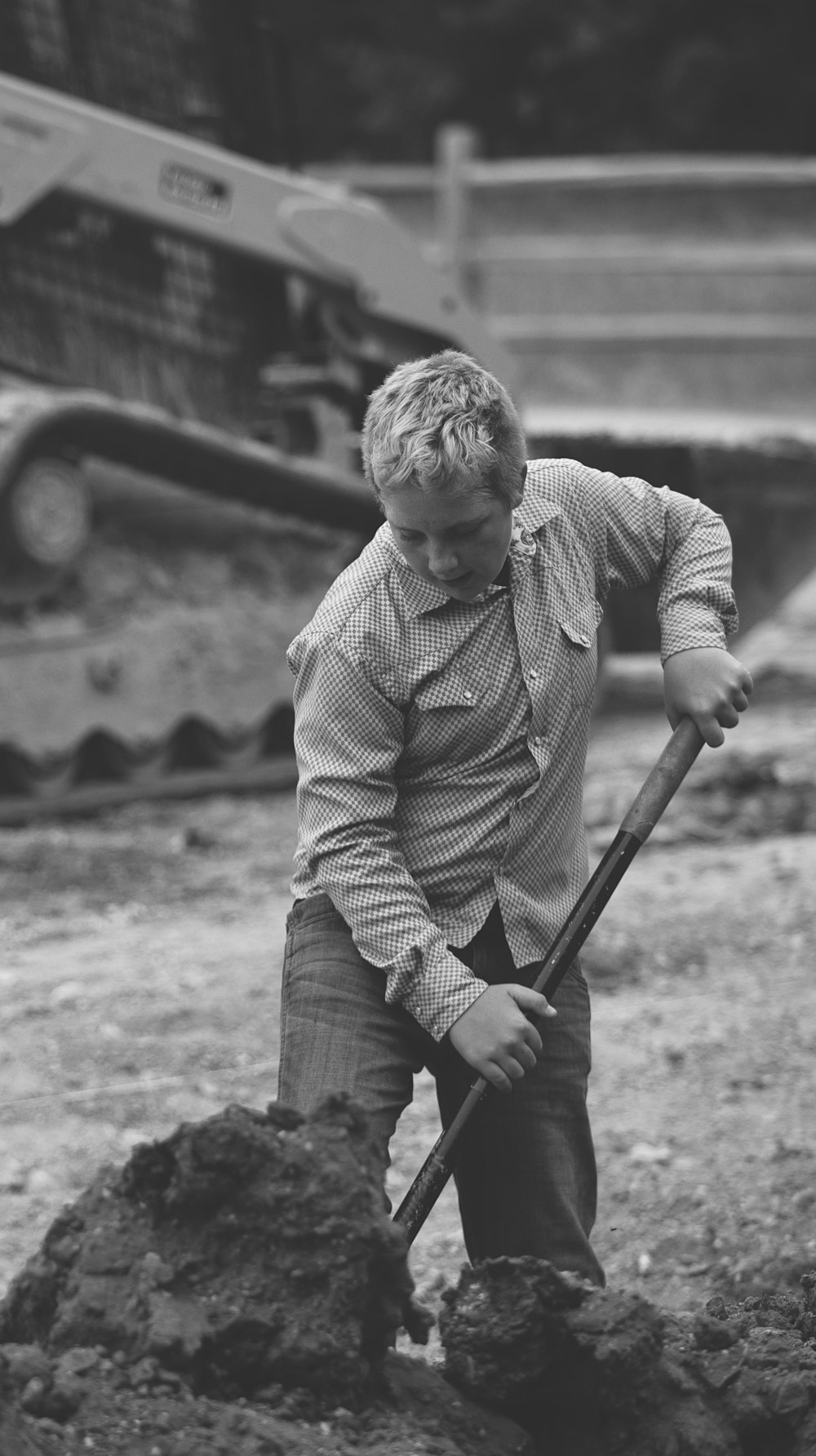 a young boy digging dirt with a shovel