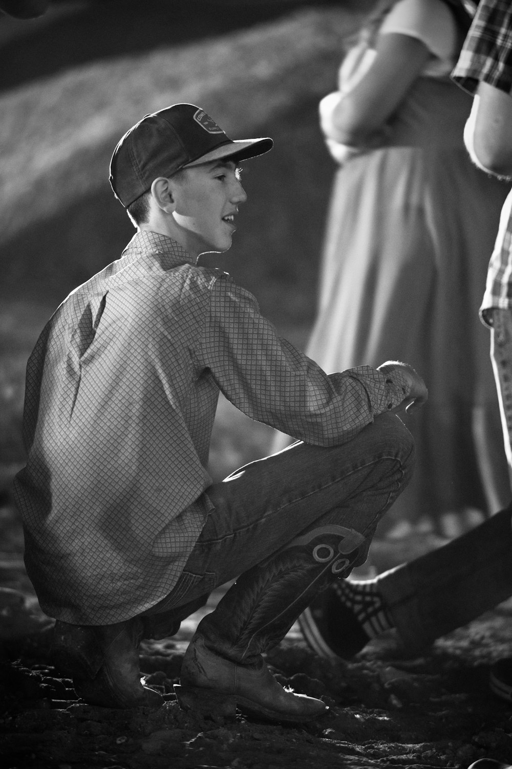 a young boy sitting on the ground with his feet on a skateboard