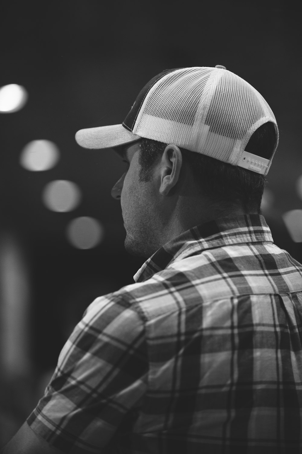 a man wearing a plaid shirt and a hat